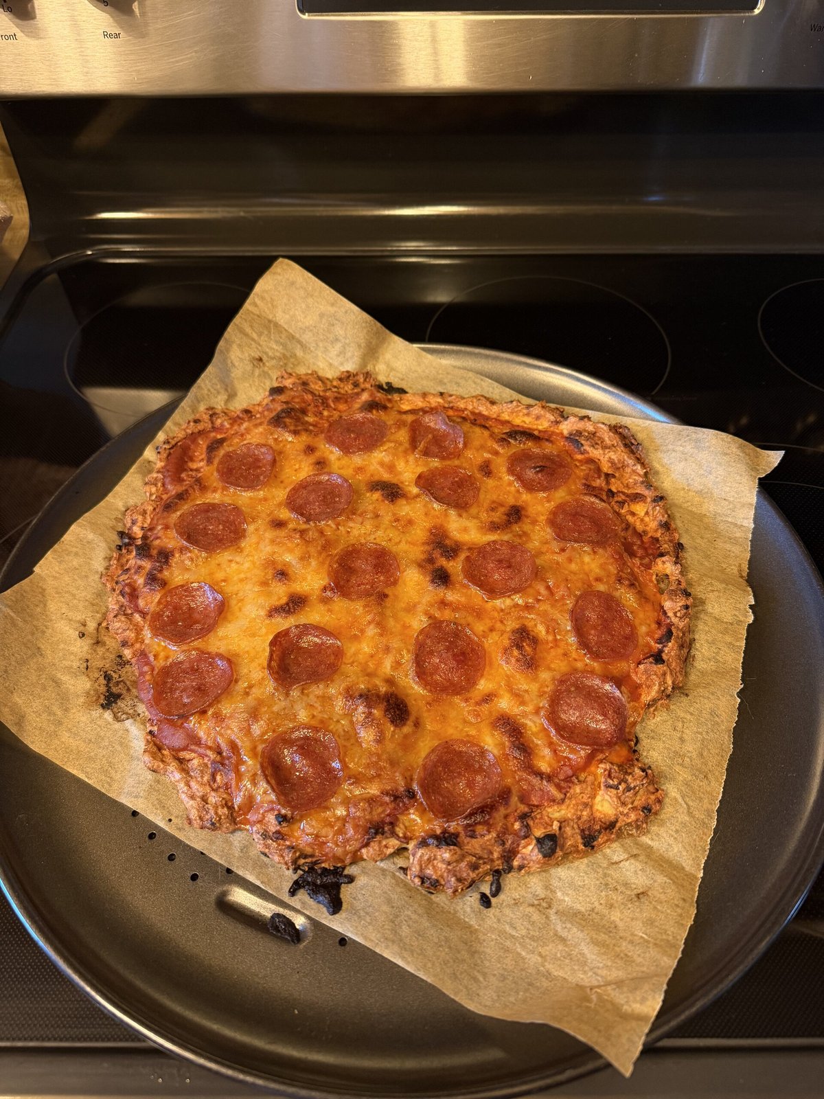 A baked chicken crust pizza topped with pepperoni and melted cheese